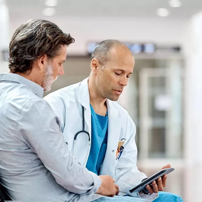 Male doctor talking to man with beard