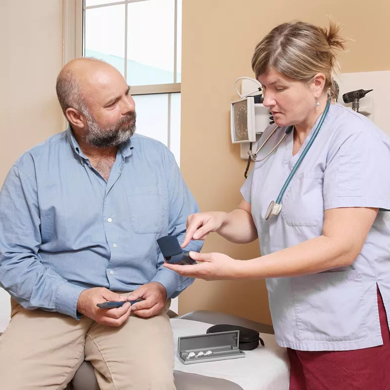 Middle aged bearded man speaks with female nurse