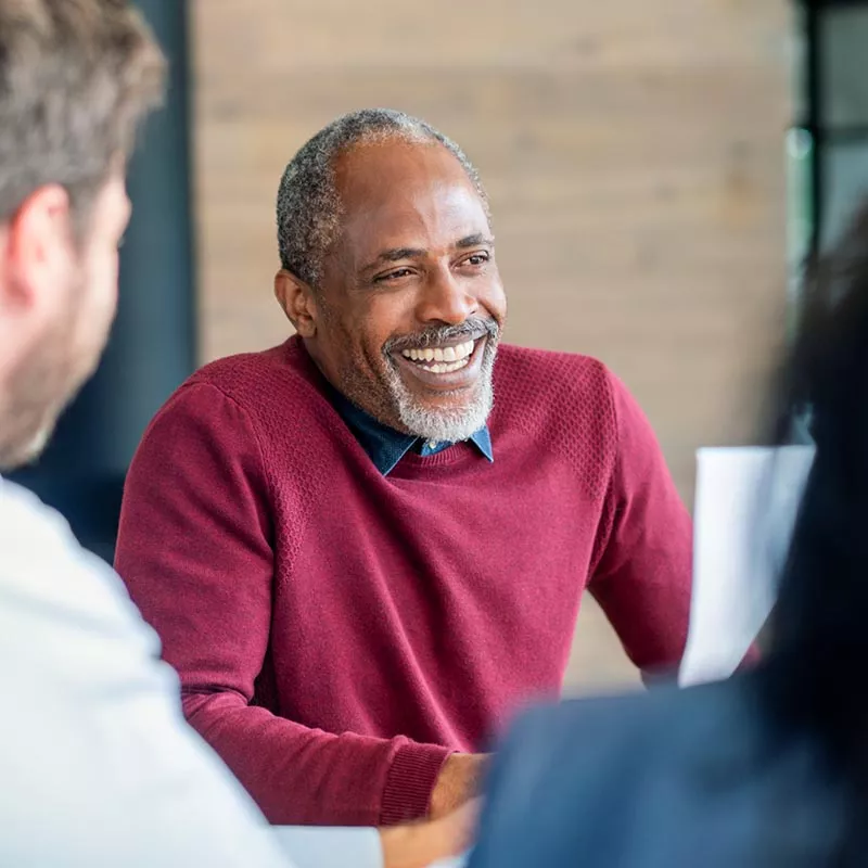 Middle aged man with beard and sweater smiling