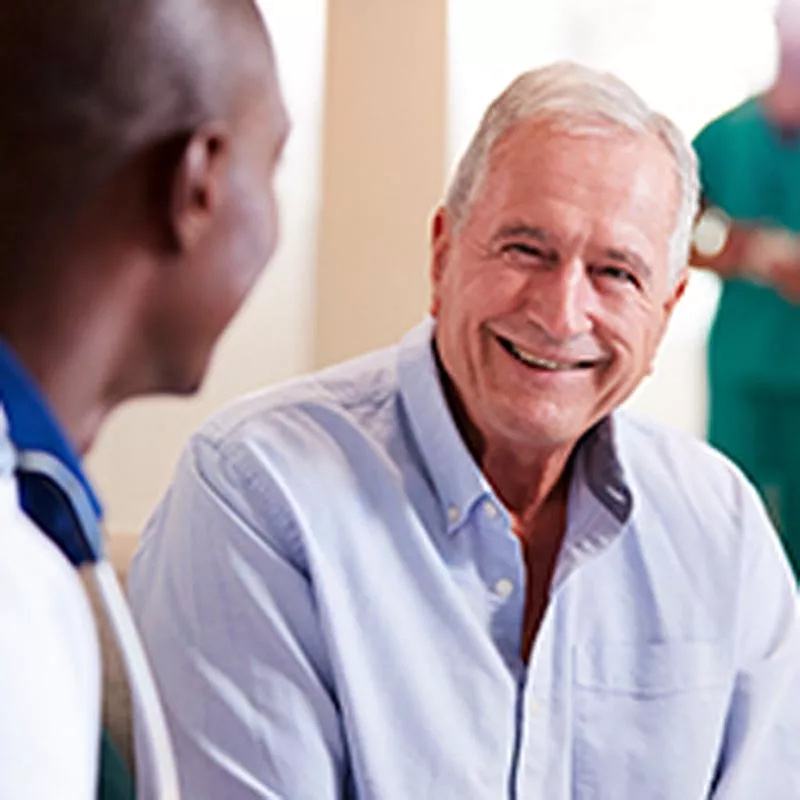 Old man smiling at man in foreground
