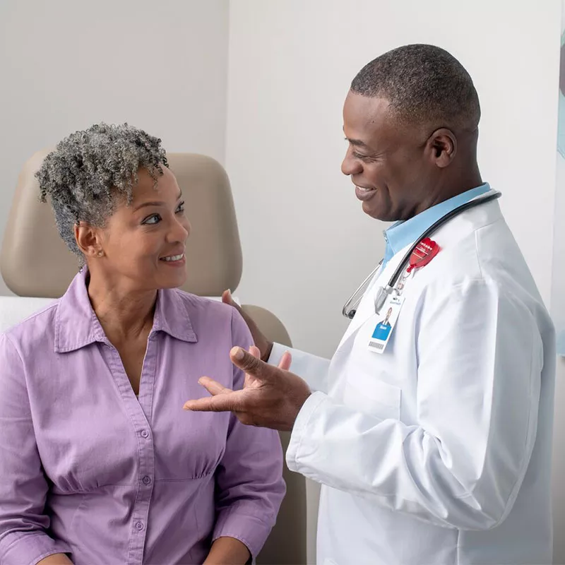 A male physician is talking to a female patient