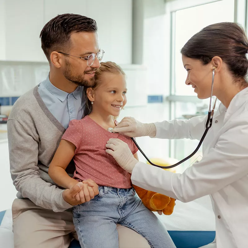 physician checking child patients heart