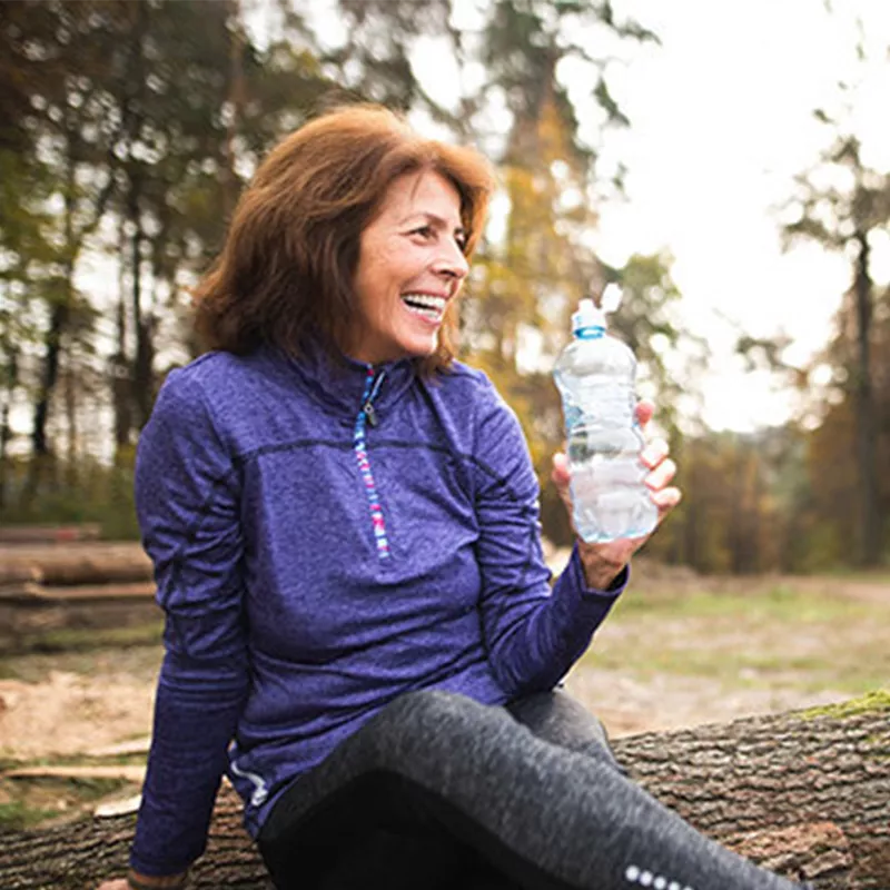 woman-seating-and-drinking-water-outdoors