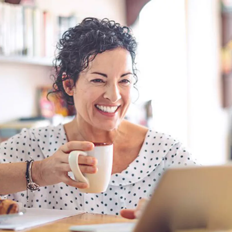 woman smiling holding a coffee mug