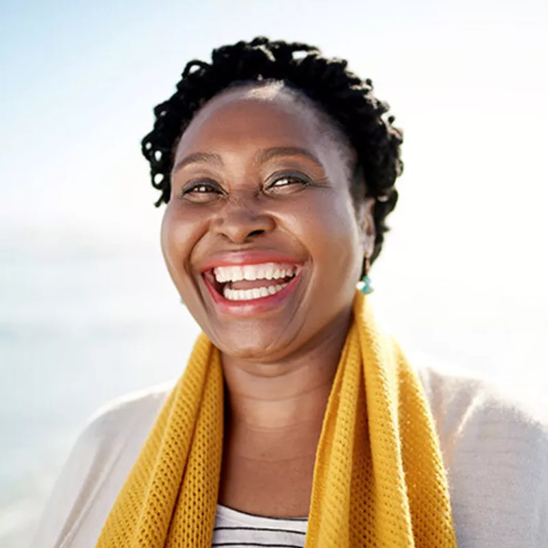 woman smiling wearing yellow scarf