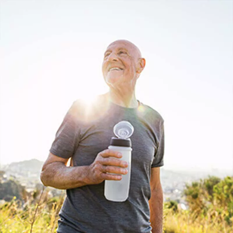 Old man holding water bottle outdoors