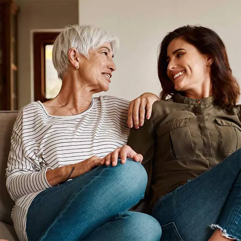 Elderly woman with adult daughter on couch