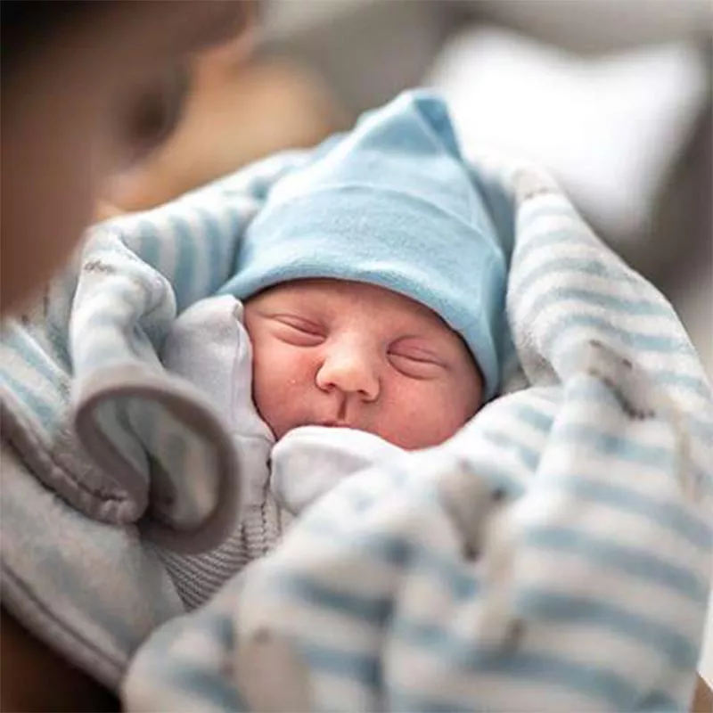 Newborn baby in hat at hospital