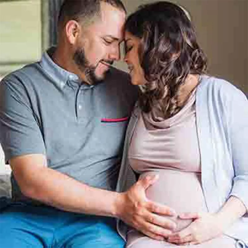 Pregnant woman and husband embracing