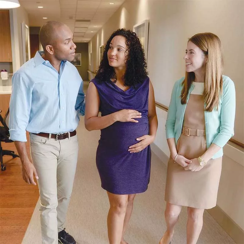 Pregnant couple with hospital staff