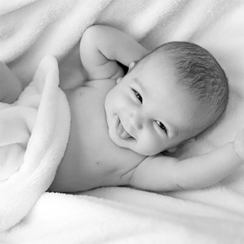 Smiling baby relaxing on bed