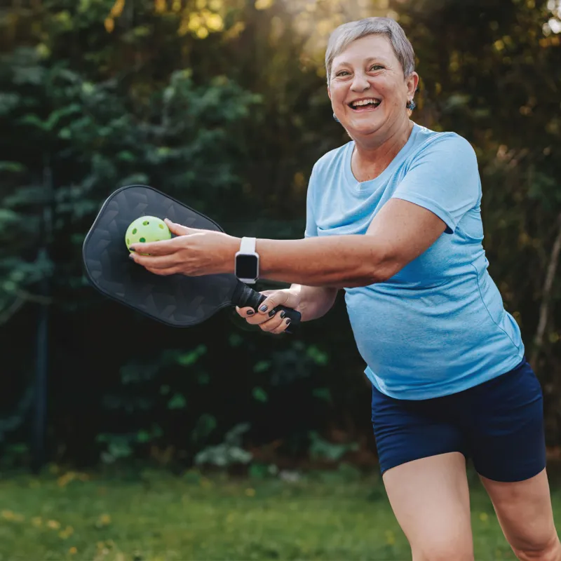 Woman playing pickleball outdoors