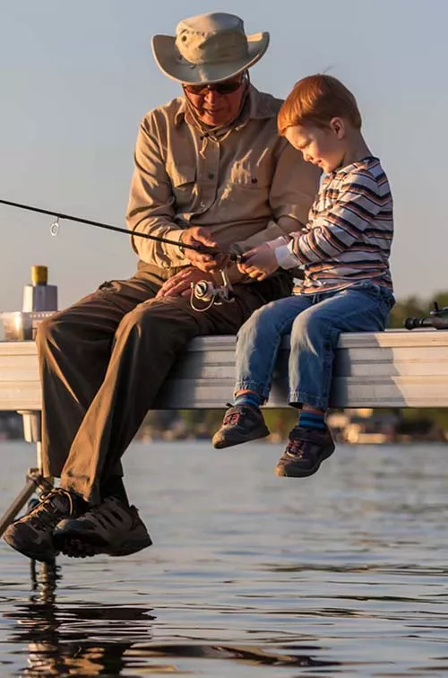 Grandfather and grandson fishing on dock
