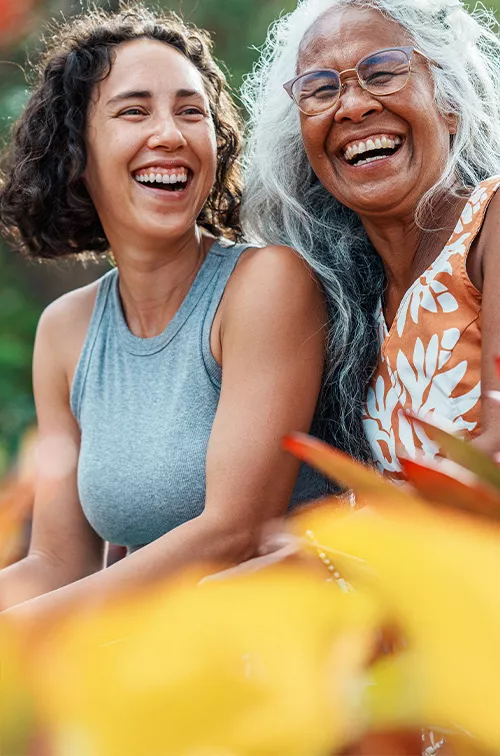 mom and daughter smiling in a garden