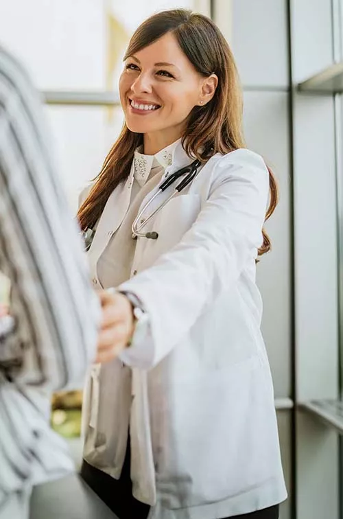 Smiling doctor reaching out to woman