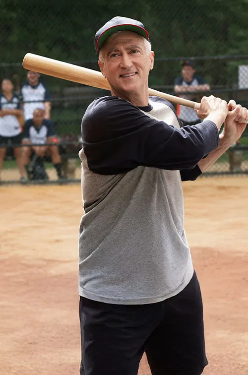 grandfather holding a baseball bat outdoors