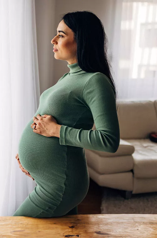 Expectant-mother-looking-out-a-window