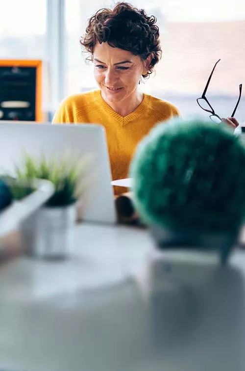 Middle-aged woman with laptop at desk