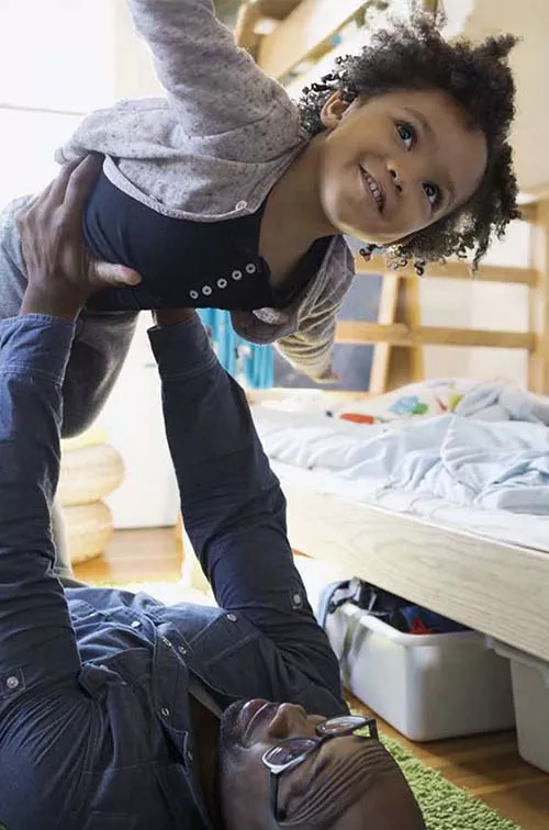 Father playing airplane and lifting his daughter up