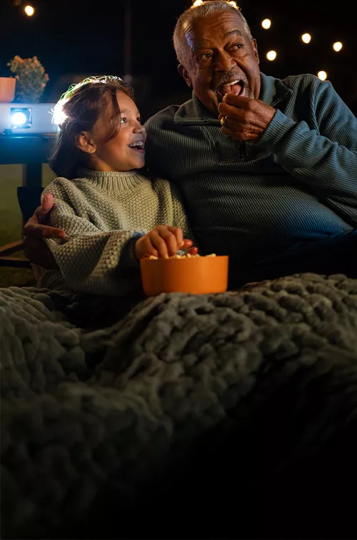 a man and his grandchild watching a movie