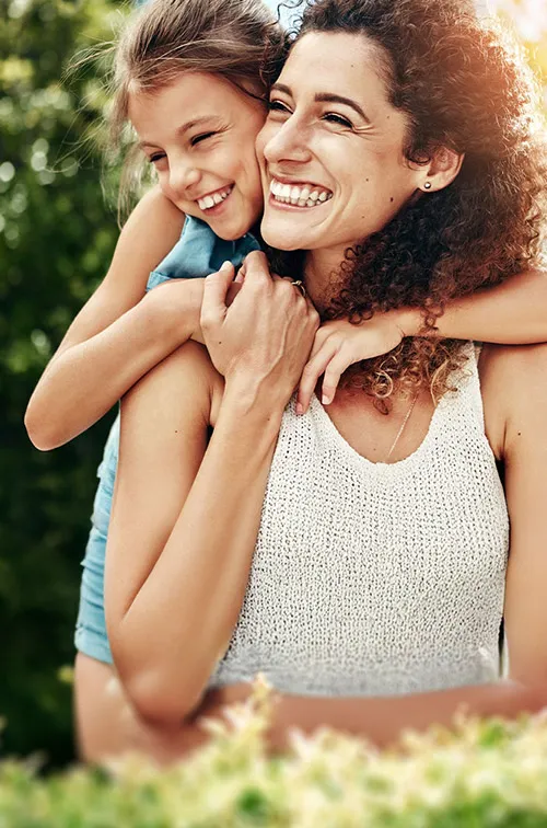 mother-and-daughter-hugging-and-laughing-outdoors